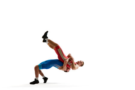Two young man, professional sportsman of freestyle wrestling in uniform fighting against white studio background. Concept of motion, action, combat sports, strength and power, movement,の写真素材
