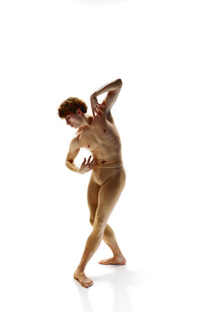 Contemporary ballet. Full length of graceful muscled man, modern ballet dancer in beige pants dancing in action against white studio background. Beauty and art, motion, inspiration concept.の写真素材