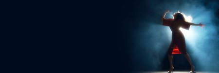 Banner. Yong artistic woman in elegant dress performing on stage against smoke and darkness. Negative space to insert text. Concept of hobby, festival, concert, disco, entertainment. Adの写真素材