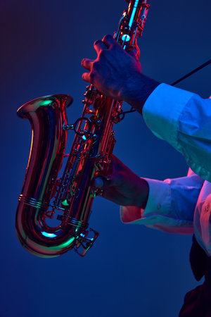 Major and Minor. Cropped photo of African-American man, holds Alto Sax and improvises jazz melodies...