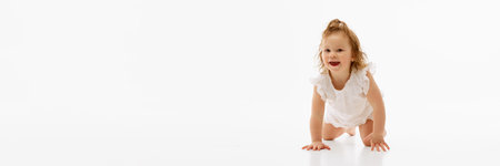 Banner. Pretty little baby, crawling across the floor in a cute dress against white background with...