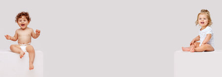 Banner. Collage. Little baby boy and girl sitting and smiling against grey studio background with negative space to insert text. Concept of childhood, motherhood, family, health, care. adの写真素材