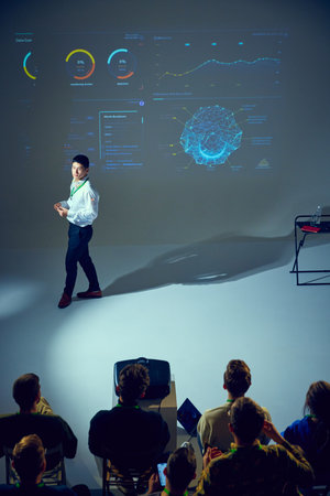 Technology seminar with Asian man presenter, speaker discussing complex data points in front of...