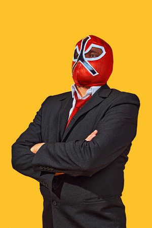 Portrait of confident man in wrestler attire with mask in official attire crossed hand on breast...