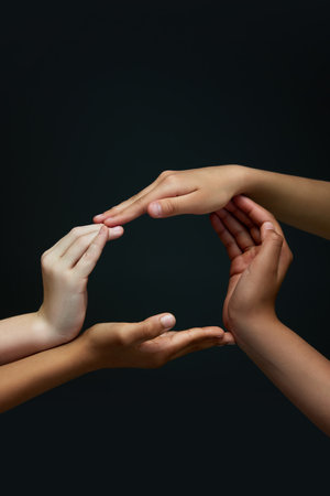 One whole. Diverse childrens hands making circle against black background. Racial equality spirit....