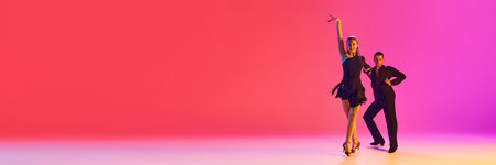 Banner. Talented ballroom dancers practicing dance moves in stages costumes in neon lighting against gradient background. Concept of dance and music, professional sport, action, competition, classicalの写真素材
