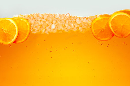 Close up photo of exotic drink with ice cubes and slices of sweet and sour citrus fruit, orange. Textured photo. Abstract wallpaper. Concept of food and drinks, summer,vitamins, nutrition.の写真素材