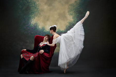 Young ballerina softly interacted with her sleeping in chair partner. Dancers in scene of famous performance against vintage style background. Concept of art, fusion of classic and modernity.の写真素材