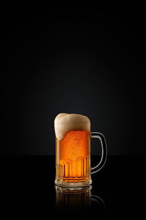Glass mug of cold, refreshing, golden beer, topped with thick white foam against black studio background. Concept of alcohol drinks, party, summer, traditions, Oktoberfest. Adの写真素材