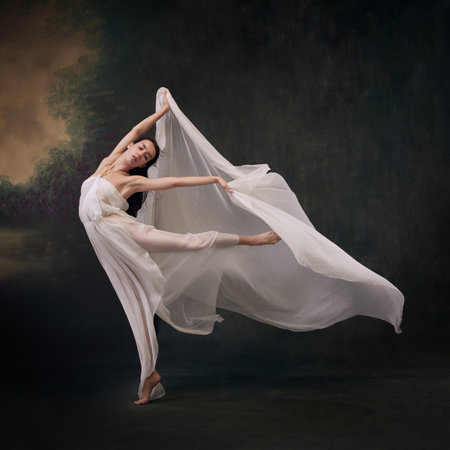 Dancers graceful jump captured with her gown billowing like wings against vintage studio background. Concept of ballet, history and classic, fusion of modernity and ancient times in art.の写真素材