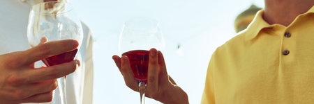 Banner. Two male friends come together for toast, their glasses meeting in celebratory gesture under...
