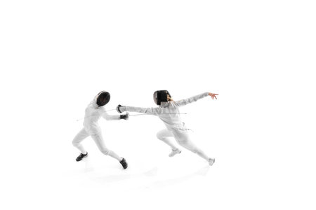 Fencing partners spar in controlled practice, each working to enhance their strategy and execution against white studio background. Concept of professional sport, competition, power, action. Adの写真素材