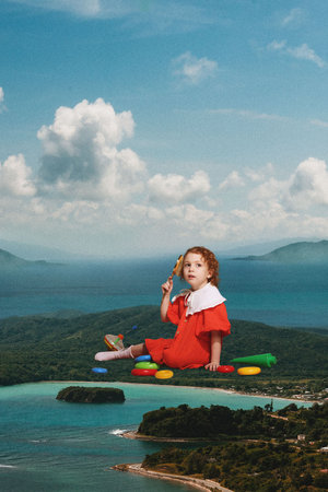 Contemporary art collage. Child in red dress playing colorful toys, sitting on coastline, capturing essence of carefree summer adventures. Concept of recreation, relax, tourism, people and nature.の写真素材