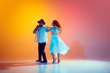 Joy and energy of Latin dance. Practicing salsa with enthusiasm, pair refines their dance-skills in neon light against gradient background. Concept of dance, performance, art, entertainment. Adの写真素材