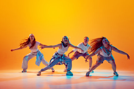 Wow wave. Group of energetical, emotional dancers performing hip-hop moves in vibrant neon light...
