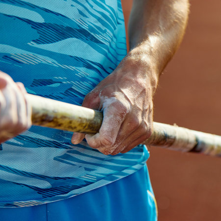 Determined pole athlete getting ready to conquer the bar, cropped image of male hands in chalk...