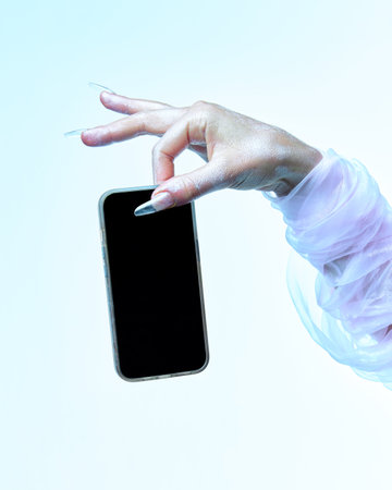 Hand of spooky white ghost holding smartphone with blank screen against gradient background. Concept of season sale, promotion, celebration, web. Negative space to insert text. Adの写真素材