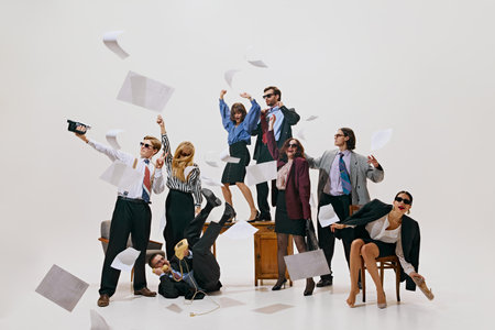Unexpected office moment. Papers fly around in burst of energy as team celebrates or creates chaos in lively office workspace against white background. Concept of corporate culture, leadership. Adの写真素材