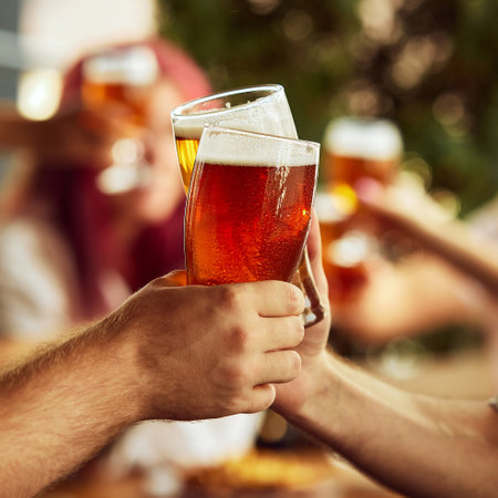 Dynamic toast among sport fans, glasses brimming with beer. Background blur emphasizes shared excitement. Selective focus. Concept of Oktoberfest, brewery, vacation, Friday mood.の写真素材
