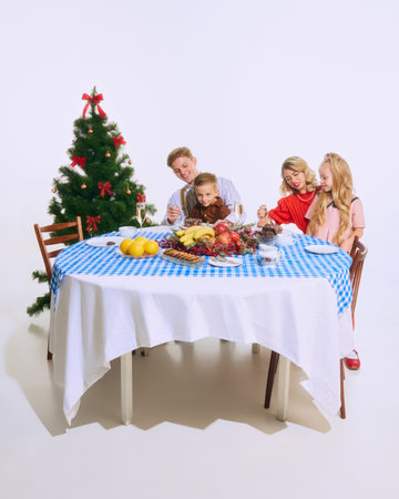 Family sits at beautifully decorated holiday table, enjoying Christmas desserts. Their smiles reflect joy of festive season. Concept of Christmas, family, joy, holiday meal, celebration.の写真素材