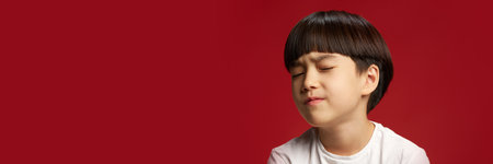 Banner. Child with eyes closed in exaggerated pain expression, scrunching his face against bold red...