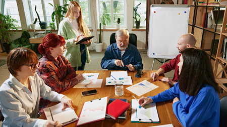 Group of business professionals engage in brainstorming session, surrounded by charts and graphs, in...