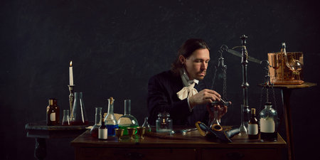 Young man, dressed vintage costume sitting in vintage laboratory and study of ancient remedies...