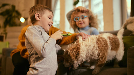 Boy laughing while girl examines dogs health under grandmothers supervision, fun activity highlighting importance of hands-on learning for health care basics. Concept of knowledge about medicine.の写真素材