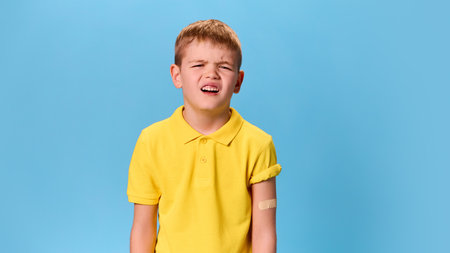 Boy grimacing slightly, bandaged arm visible, creating expressive moment of exaggerated discomfort...