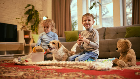 Boy holds medical toy, smiling during pretend check-up session, girl and dog sit nearby, promoting teamwork and medical curiosity. Concept of knowledge about healthy lifestyle and medicine.の写真素材
