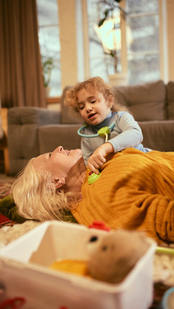 Grandmother laying down while children role-play doctors, building childrens confidence in health-related activities. Concept of knowledge about healthy lifestyle and medicine.の写真素材