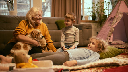 Children smiling during mock health check-up with grandmother nearby, creating positive association with healthcare and medical learning activities. Concept of knowledge, healthy lifestyle, medicine.の写真素材