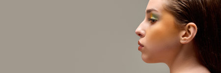 Banner. Extremely close-up of young woman with stylish, bright make-up against warm grey background with negative space to insert text. Concept of natural and artificial beauty, fashion and style.の写真素材