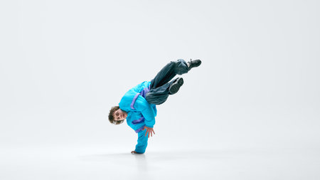Breakdancer spinning low, hand stabilizing movement, legs suspended, core engaged in perfect motion....
