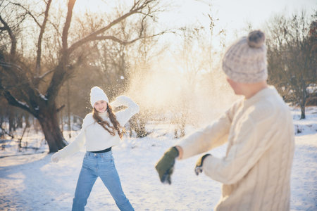Happy couple dressed warm stylish and comfy clothes, running outside, enjoying time together. Concept of winter, vacation, human emotions, nature, leisure time.の写真素材