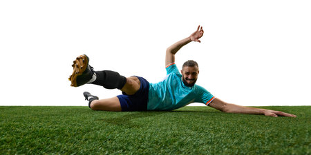 Football athlete diving onto green field, stretching arm and legs in final effort during intense match, face showing determination. Concept of persistence, sports competition.の写真素材