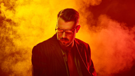 Man in suit lowers head with eyes closed in saturated red light suggesting emotional surrender....