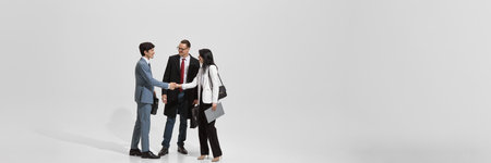Banner. Successful business negotiation culminates in handshakes against white backdrop, shows...