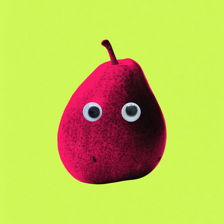 Creative artwork. Red pear with plastic googly eyes floats on lime green background, disturbing innocence of fruit through cartoon absurdity. Concept of fast food, fun discomfort.の写真素材