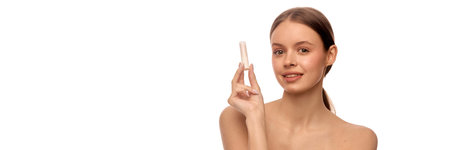 Woman holding lip balm with soft smile and natural bare shoulders, clean glowing skin and makeup...