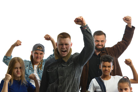 A diverse group stands united in protest, raising fists with determined expressions against a white...