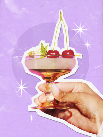 A hand holds a cocktail glass with cherries against a vibrant purple paper cut collage background. Concept of creative design in beverage marketing and art.の写真素材