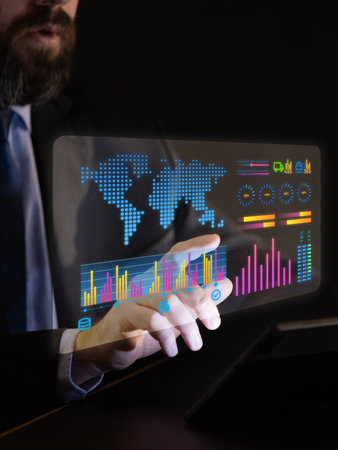 Male hand interacts with futuristic transparent interface showing global charts, logistics stats,...