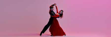 An elegant couple dances the Argentine tango on a softly lit pink stage background. Concept of...