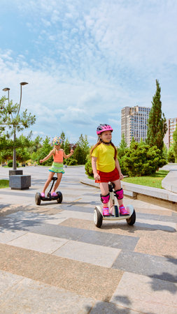 Smart balance. Children use swegways in an urban park environment on a sunny day, illustrating the concept of contemporary outdoor activities for kids. Concept of motor skills and mobilityの写真素材