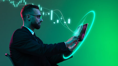 Businessman analyzing candlestick chart on digital tablet with green glow. Concept of trading...