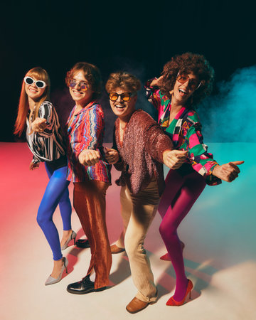 Retro group in bold disco costumes pointing playfully at camera. Concept of vintage lifestyle, pop culture advertising, funky fashion promotion, and disco celebration campaigns.の写真素材