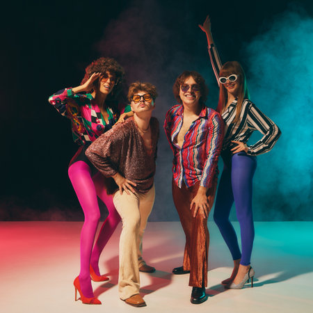 Vintage styled disco group dancing with dramatic colorful smoke. Concept of nostalgic fashion campaigns, pop culture events, retro parties and empowered expressive lifestyle.の写真素材