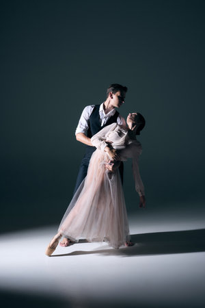 Ballet couple in dramatic embrace with elegant posture and emotional tension. Concept of editorial dance, expressive movement, romance, and conceptual art.の写真素材