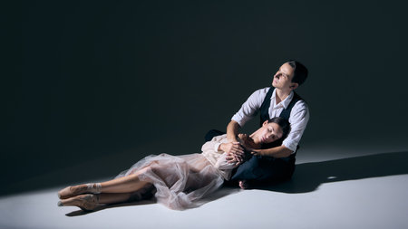 Dancers in intimate seated pose with contemplative mood and gentle embrace. Concept of romance,...